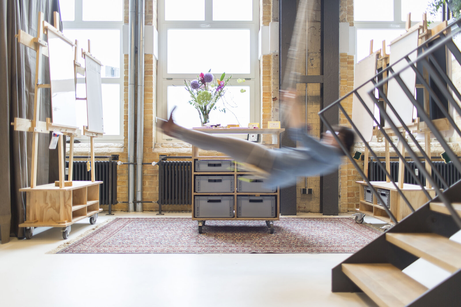 Bewegung im Loft der Base⁷ Esslingen: Flipchart-Staffeleien vor Backsteinwand, ideal für Team-Offsites